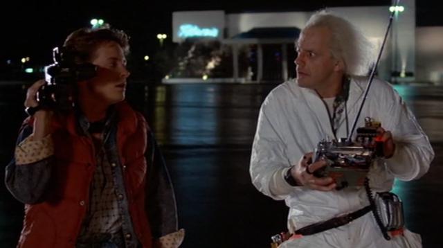 Screenshot of Marty sidling away from the Doc as the Delorean is about to speed towards them, and the Doc looking at him accusingly