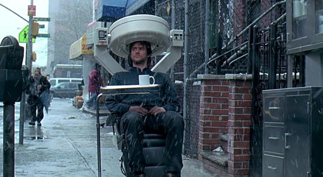 Screenshot from Eternal Sunshine of the Spotless Mind - Joel is in the scanning chair, on a New York street