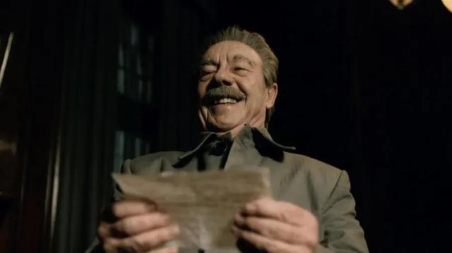 Screenshot from The Death of Stalin, of Stalin laughing right before he has a stroke